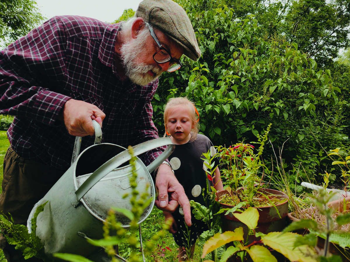 grandad and grandchild watering garden