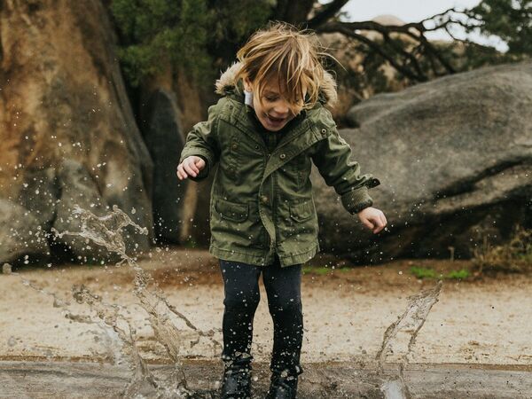 child splashing in puddle_landscape